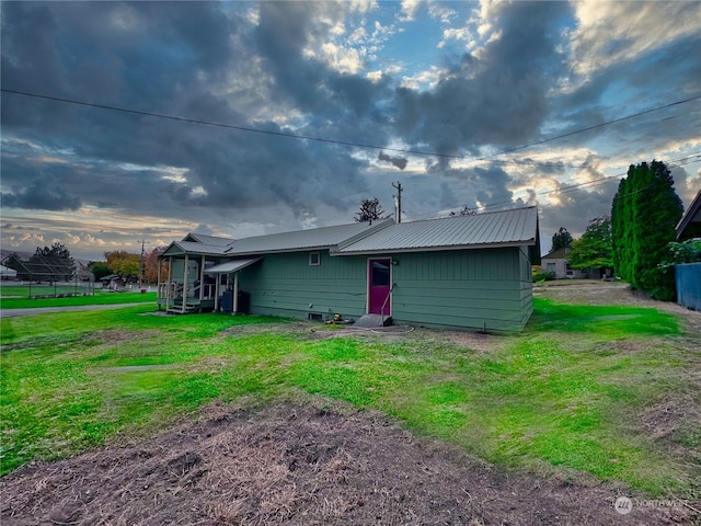 back of house featuring a lawn