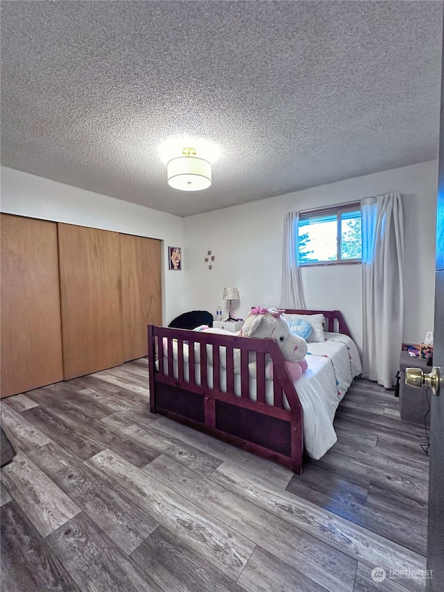 bedroom featuring wood-type flooring and a textured ceiling