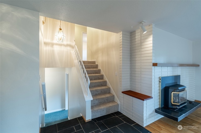 stairway featuring a wood stove and wood-type flooring