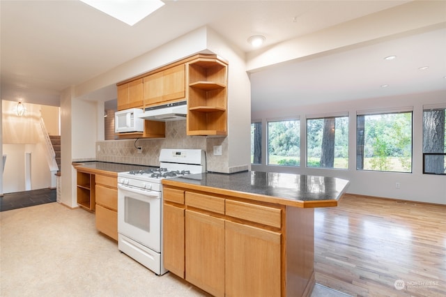 kitchen with light hardwood / wood-style floors, kitchen peninsula, tasteful backsplash, and white appliances