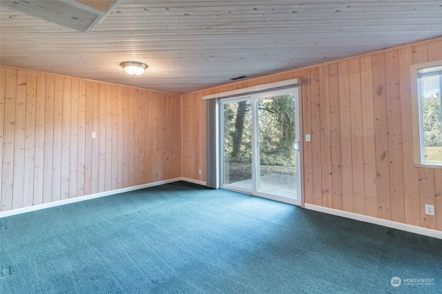 spare room featuring wood walls, carpet, and wooden ceiling