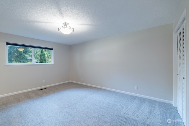 interior space featuring a closet, carpet floors, and a textured ceiling