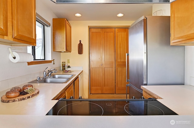 kitchen featuring stainless steel refrigerator, sink, and black electric cooktop