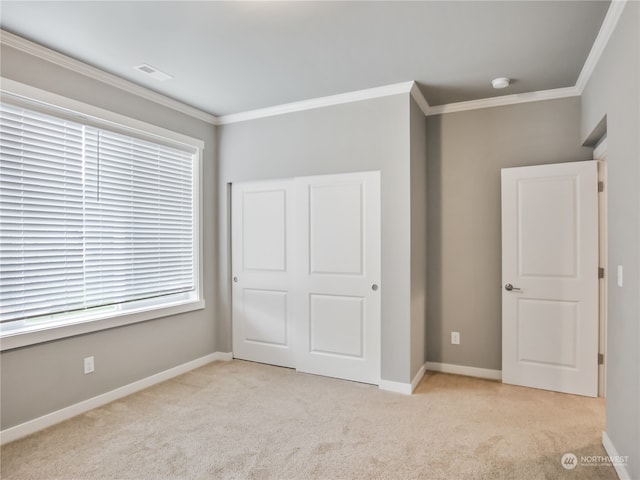 unfurnished bedroom featuring light carpet and crown molding