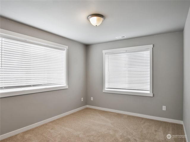 unfurnished room featuring light carpet