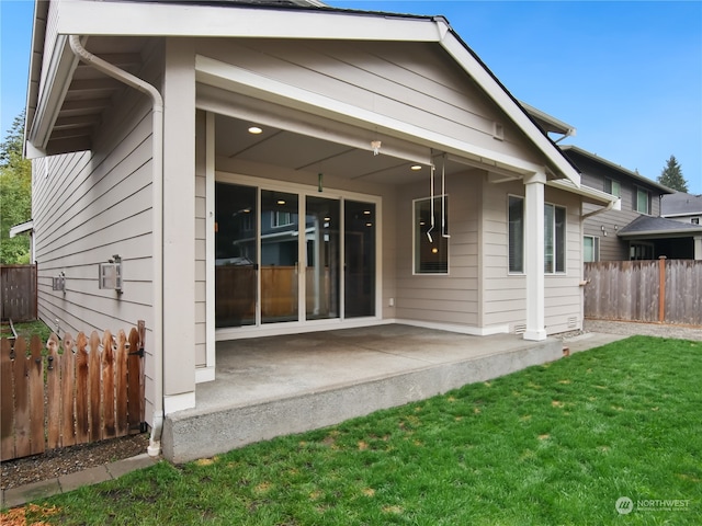 back of property with a patio and a lawn