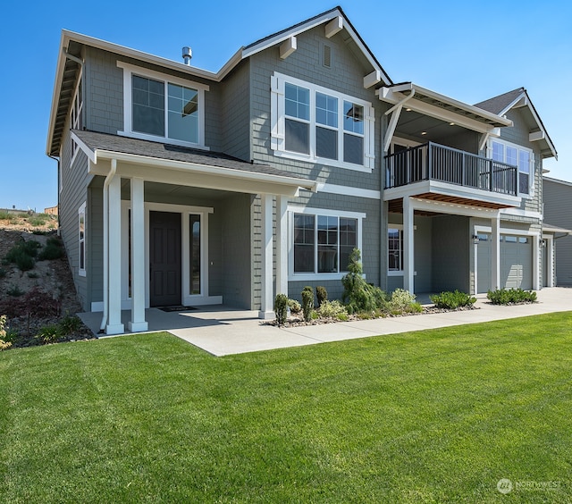 view of front of home featuring a porch, a front lawn, a garage, and a balcony