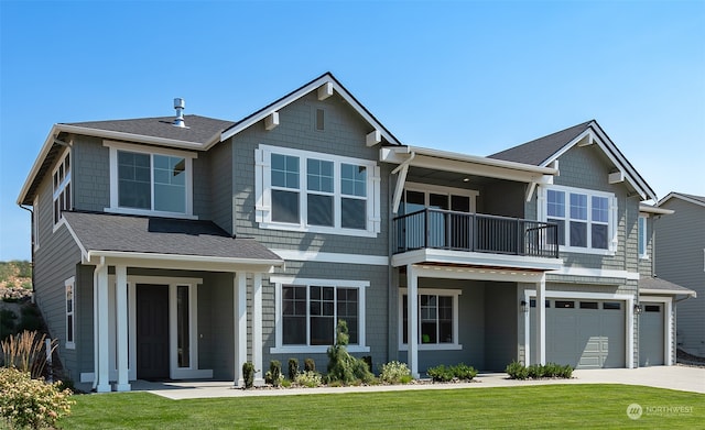 view of front of home with a front lawn, a garage, and a balcony