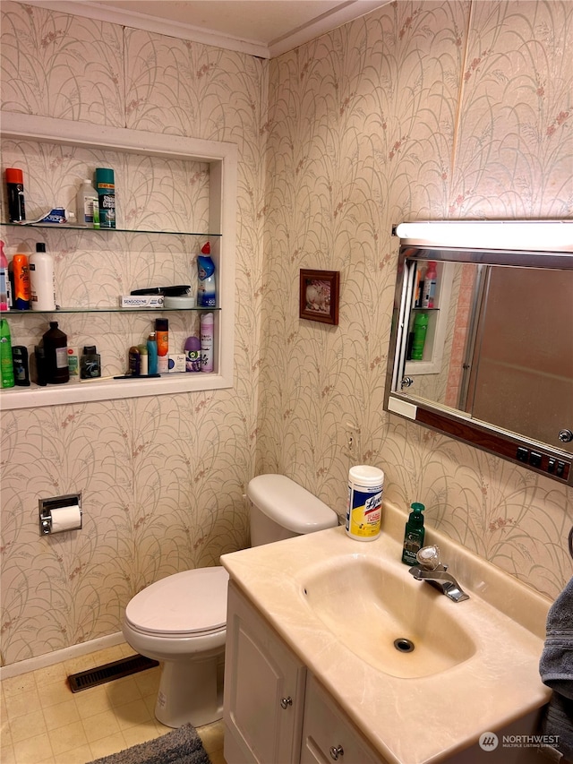 bathroom featuring tile patterned floors, vanity, toilet, and crown molding