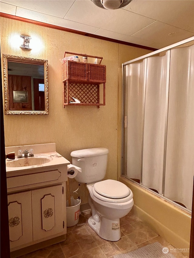 full bathroom featuring vanity, shower / bath combination with glass door, tile patterned floors, toilet, and ornamental molding