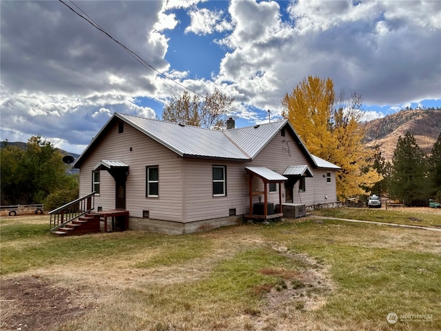 back of house featuring a lawn, a mountain view, and cooling unit