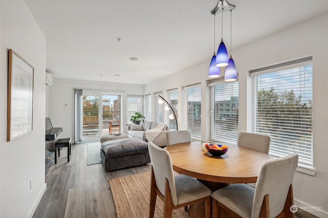 dining area featuring wood-type flooring and a wall mounted air conditioner