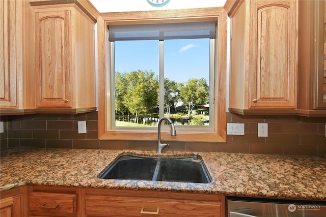 kitchen with backsplash, light brown cabinetry, sink, and dishwasher