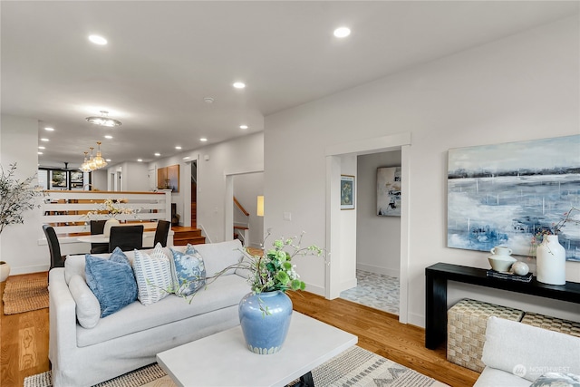 living room with an inviting chandelier and light wood-type flooring