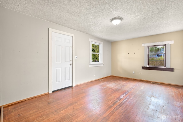 unfurnished room featuring hardwood / wood-style floors and a textured ceiling