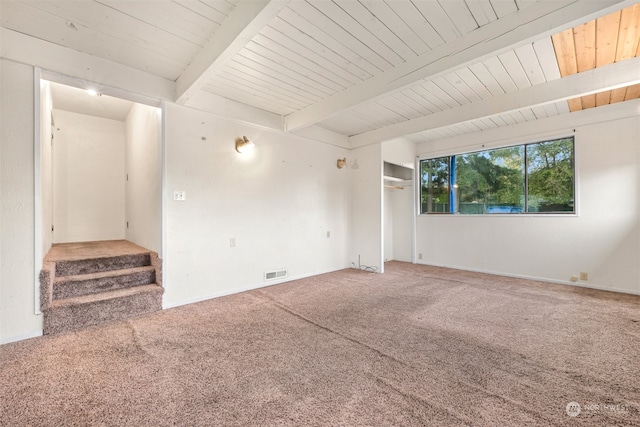 spare room featuring beam ceiling, carpet flooring, and wooden ceiling