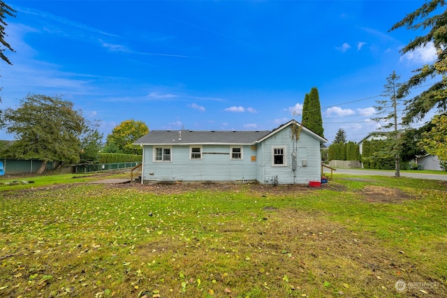 rear view of property with a yard