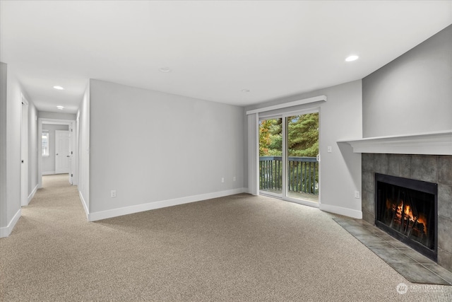 unfurnished living room with light carpet and a fireplace