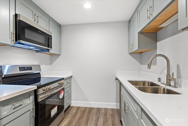 kitchen featuring gray cabinets, appliances with stainless steel finishes, dark wood-type flooring, and sink