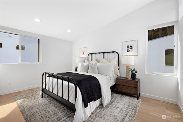 bedroom featuring light hardwood / wood-style floors and vaulted ceiling