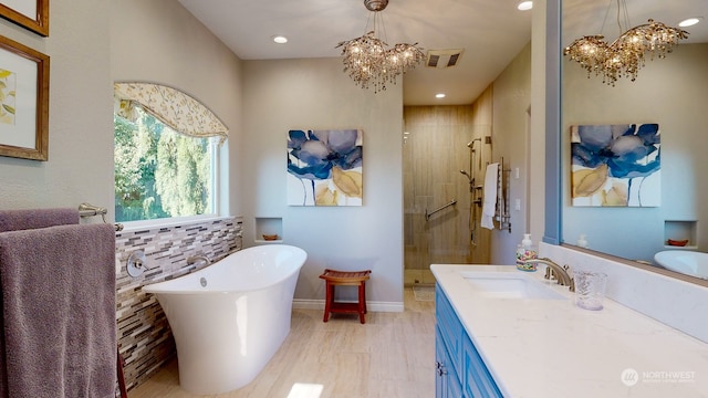 bathroom featuring vanity, a chandelier, wood-type flooring, and separate shower and tub