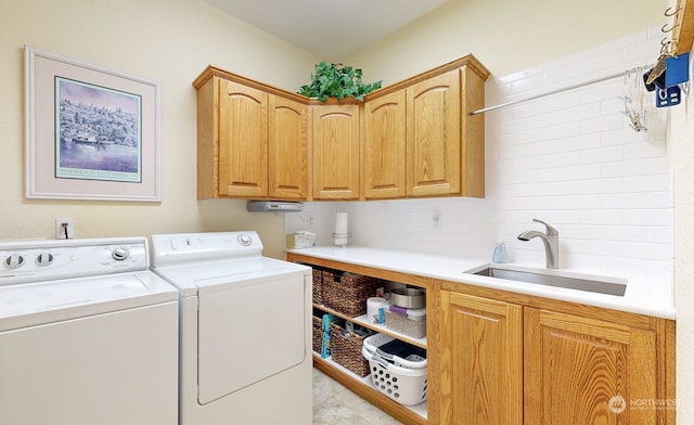 laundry area with sink, washing machine and clothes dryer, light tile patterned floors, and cabinets