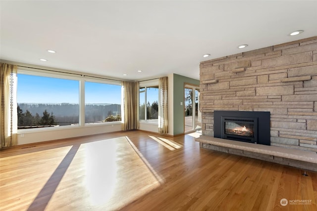 unfurnished living room with a mountain view, a fireplace, and light wood-type flooring