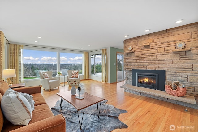 living area with recessed lighting, plenty of natural light, wood finished floors, and a fireplace