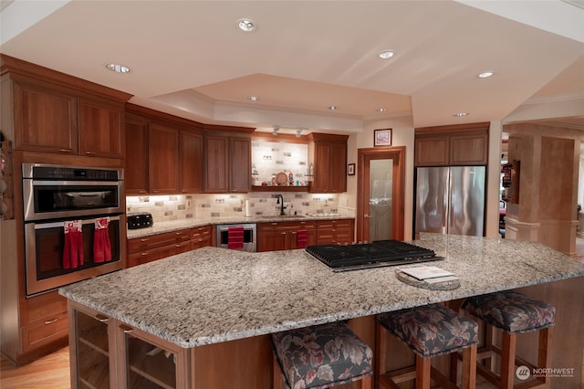 kitchen featuring wine cooler, a large island, crown molding, appliances with stainless steel finishes, and light stone counters