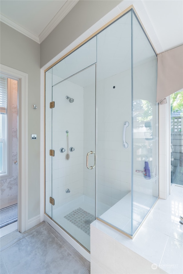 bathroom with crown molding and a shower with shower door
