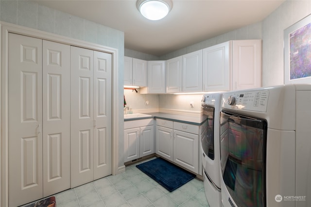 laundry area with sink, washing machine and dryer, and cabinets