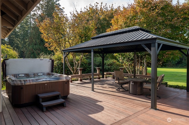 deck featuring a gazebo, a hot tub, and a lawn