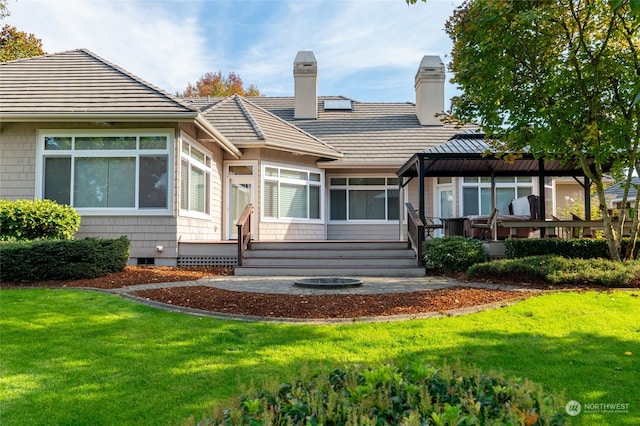 back of property with a deck and a lawn