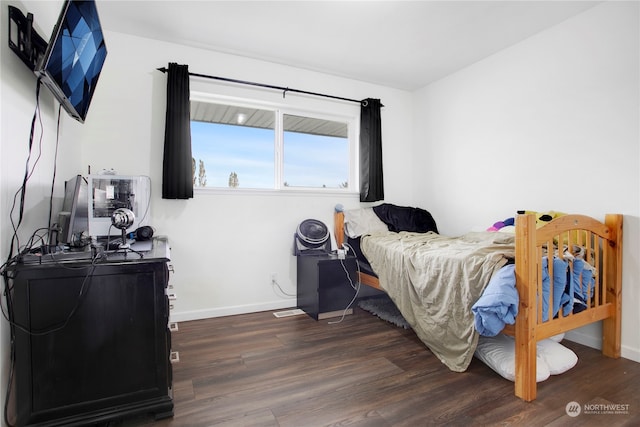 bedroom with dark hardwood / wood-style floors