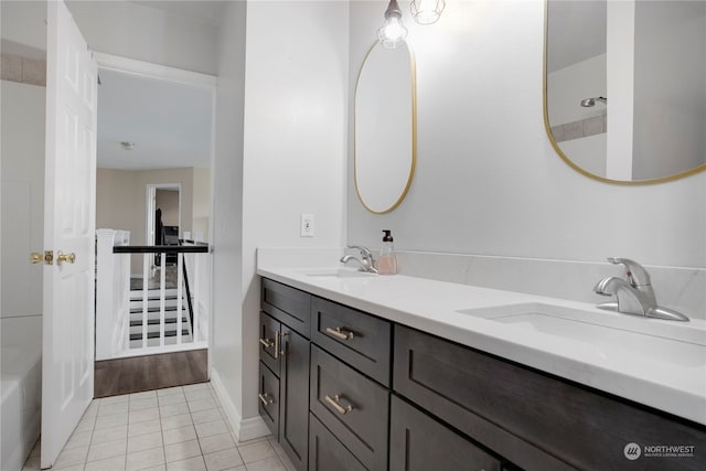 bathroom with vanity, a bathtub, and tile patterned flooring