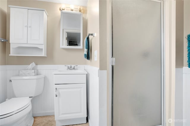 bathroom with vanity, a shower with shower door, and toilet