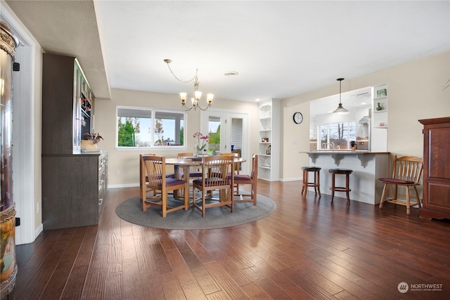 dining space featuring a chandelier, built in features, and dark hardwood / wood-style flooring