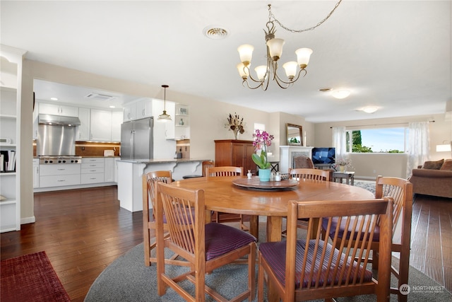 dining space featuring dark wood-type flooring and an inviting chandelier