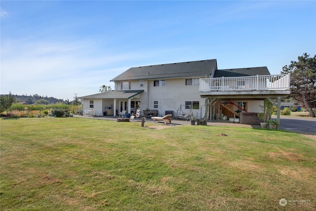 rear view of house with a patio, a deck, and a yard