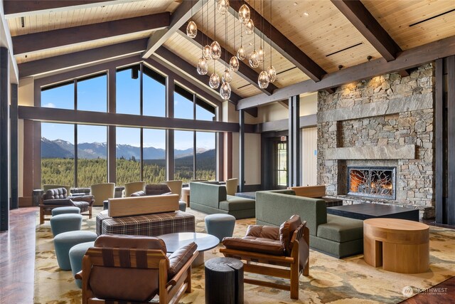 living room with beamed ceiling, a mountain view, a fireplace, and high vaulted ceiling