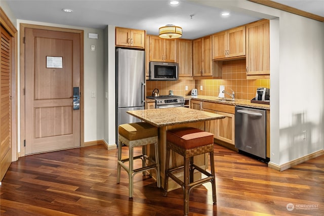 kitchen with dark wood-type flooring, light stone countertops, stainless steel appliances, and sink