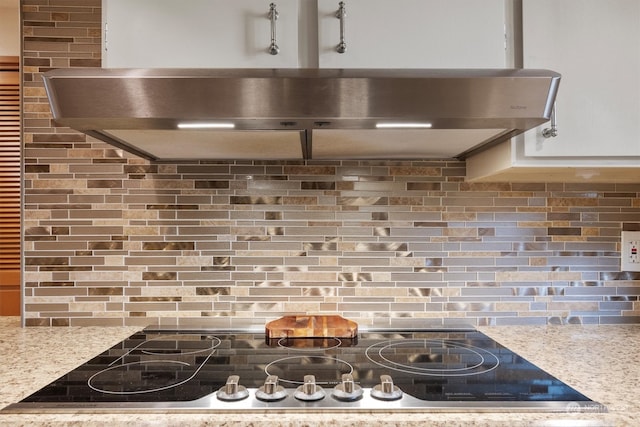 kitchen featuring light stone countertops and backsplash