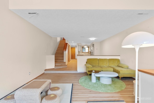 living room featuring light hardwood / wood-style flooring and a textured ceiling