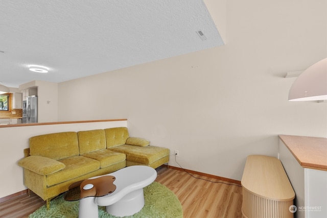 living room featuring a textured ceiling and light wood-type flooring