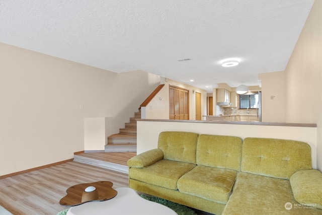 living room with light hardwood / wood-style floors and a textured ceiling