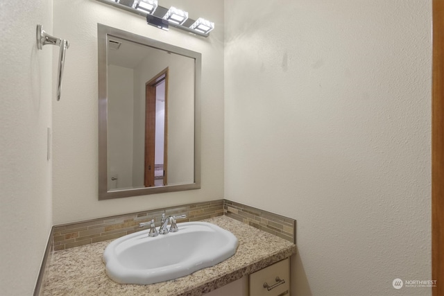 bathroom with vanity and tasteful backsplash