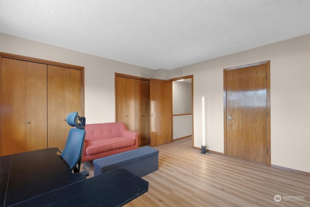 home office featuring light hardwood / wood-style floors and a textured ceiling