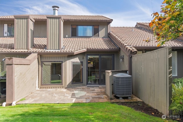 back of property with a patio area, cooling unit, and a lawn