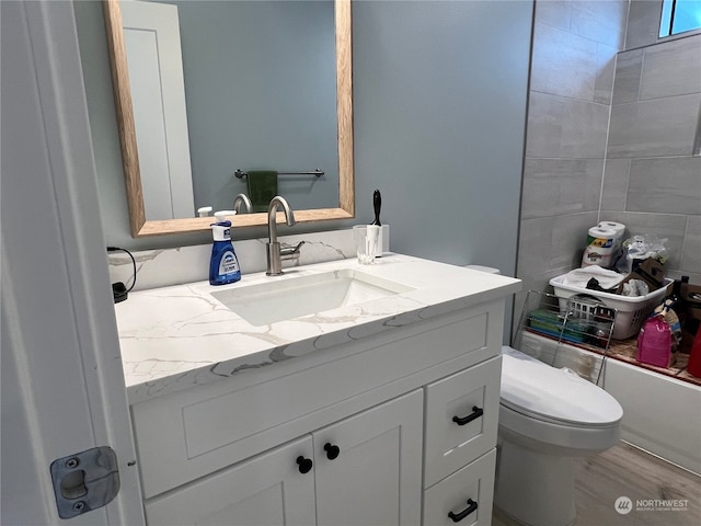 full bathroom with vanity, independent shower and bath, wood-type flooring, and toilet