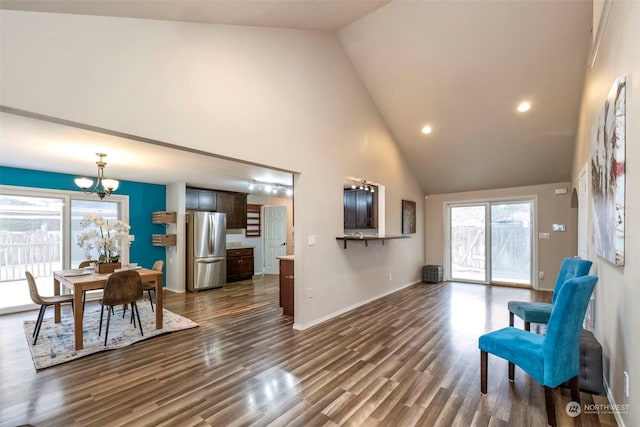 interior space featuring dark wood-type flooring, a chandelier, and high vaulted ceiling